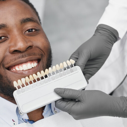 Patient smiling with teeth whitening shade chart